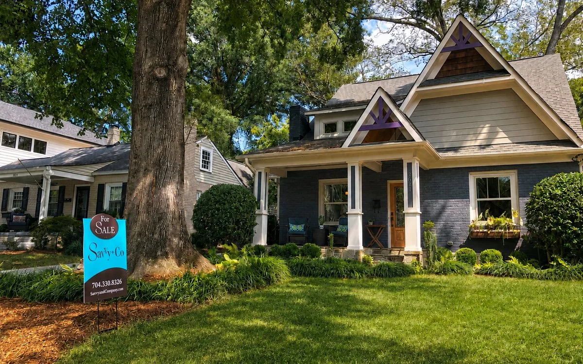 A Savvy + Co. For Sale sign in front of a Charlotte bungalow